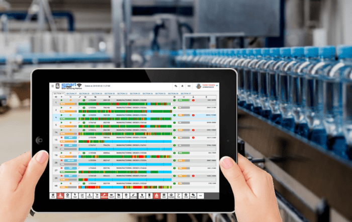 manos sujetando tablet. Pantalla de tablet mostrando el sistema MES smartmon.