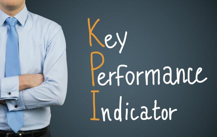 Empresario y dibujo del símbolo KPI sobre fondo oscuro